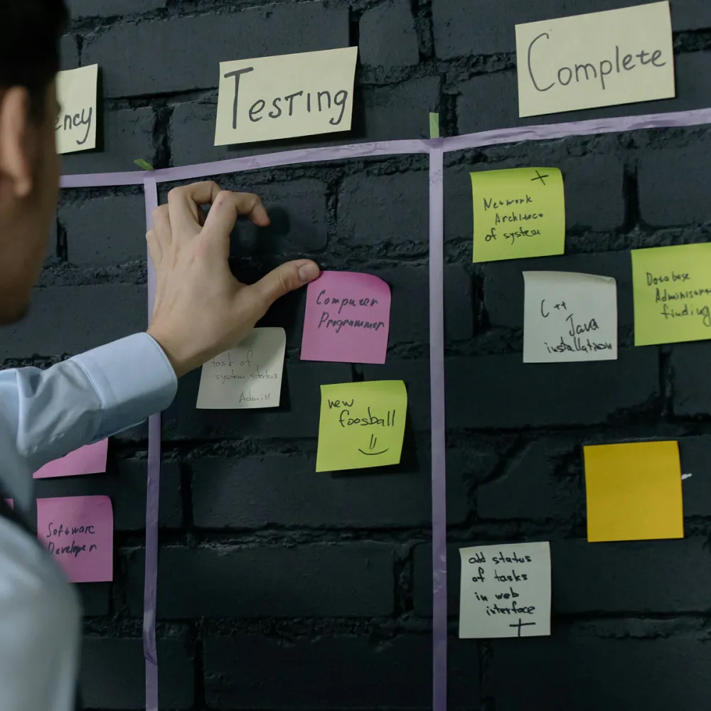 Kanban template on wall with project manager organising priorities Kanban template on wall with project manager organising priorities